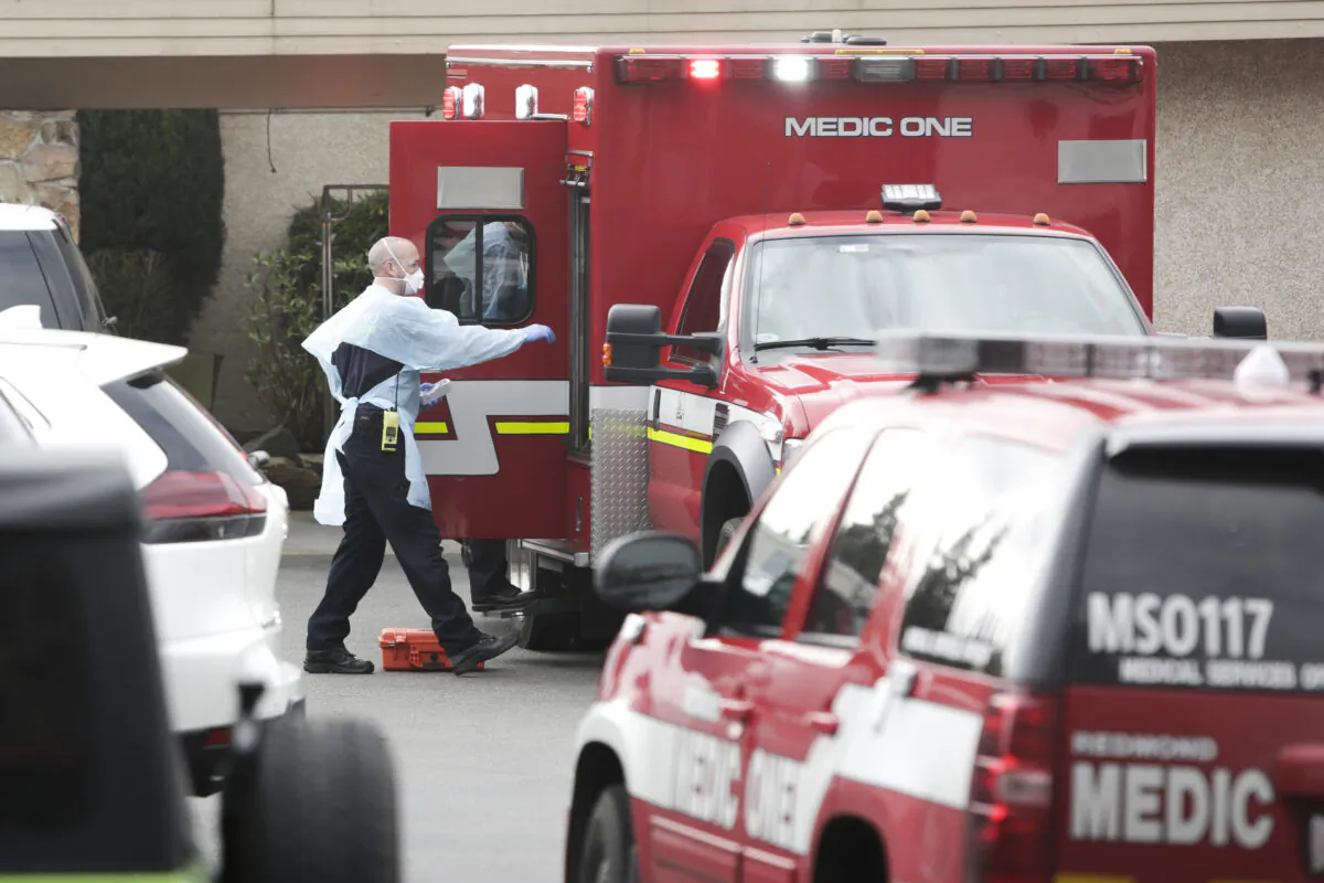 Ambulance staff prepare to transport a patient from the Life Care Center nursing home where some patients died from COVID-19, in Kirkland, Wash., on March 5, 2020. (Jason Redmond/AFP via Getty Images)