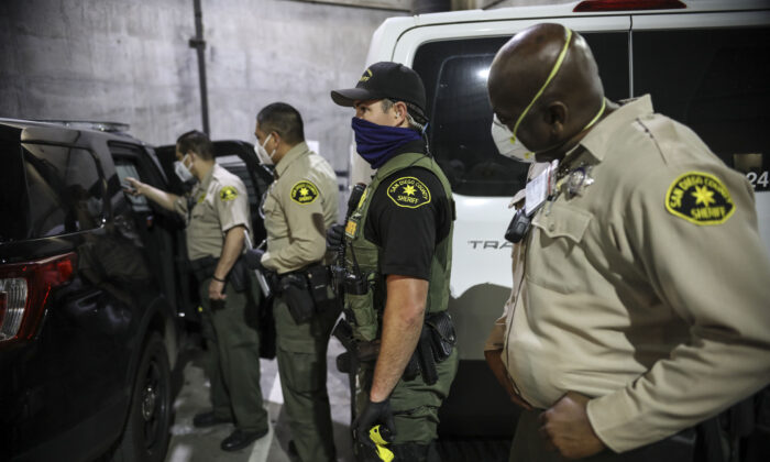 Sheriff's deputies line up before taking a man into booking at the San Diego County Jail in San Diego, Calif. on April 24, 2020. (Sandy Huffaker/Getty Images)