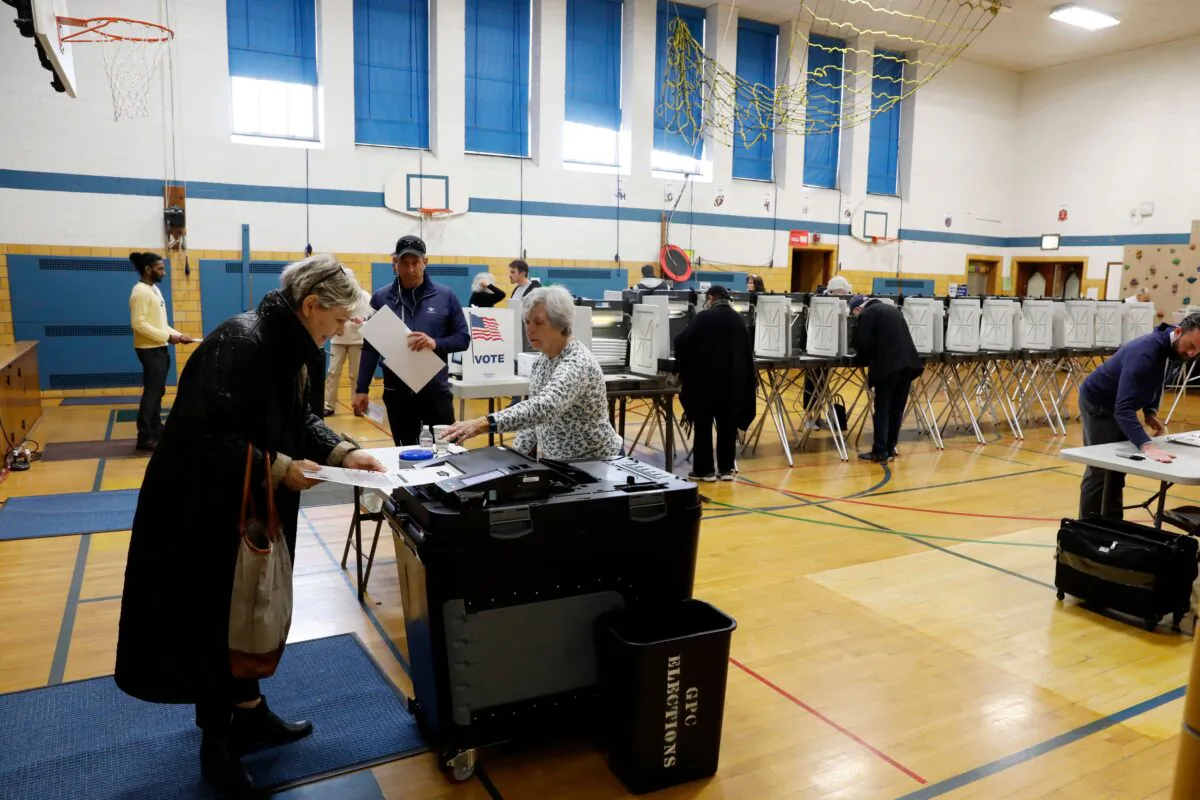 People put ballots in a tabulation machine in Grosse Pointe, Mich., on March 10, 2020. (Jeff Kowalsky/AFP via Getty Images)