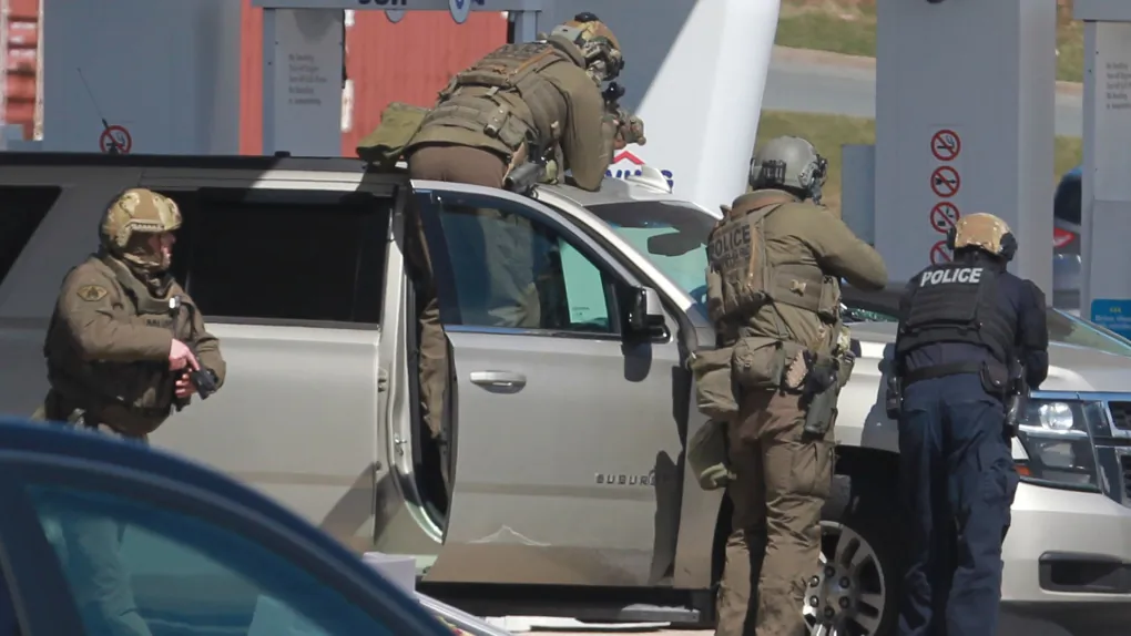 RCMP officers prepare to take a person into custody at a gas station in Enfield, N.S. on April 19, 2020. (The Canadian Press/Tim Krochak)