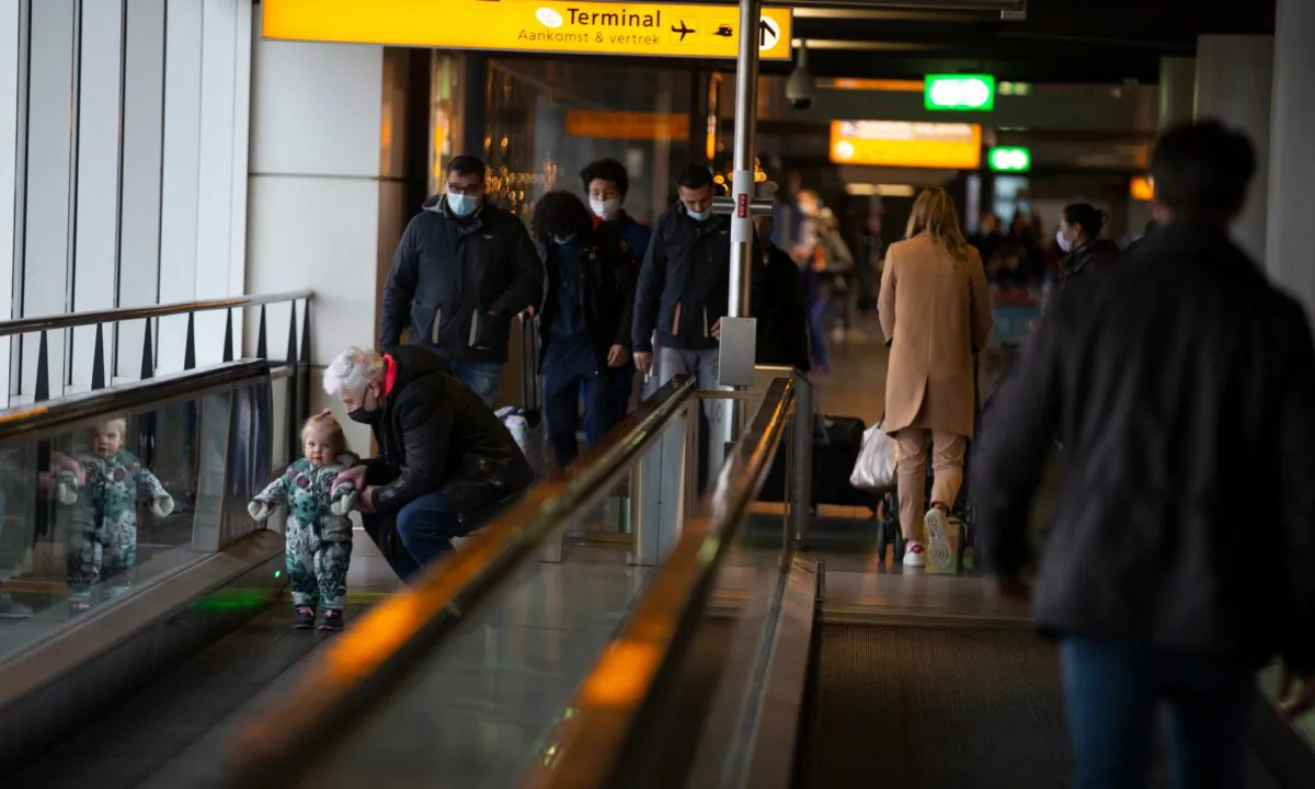 Arriving and departing passengers use the flat escalators at Schiphol Airport, near Amsterdam, Netherlands, on Dec. 18, 2020. (Peter Dejong/AP Photo)