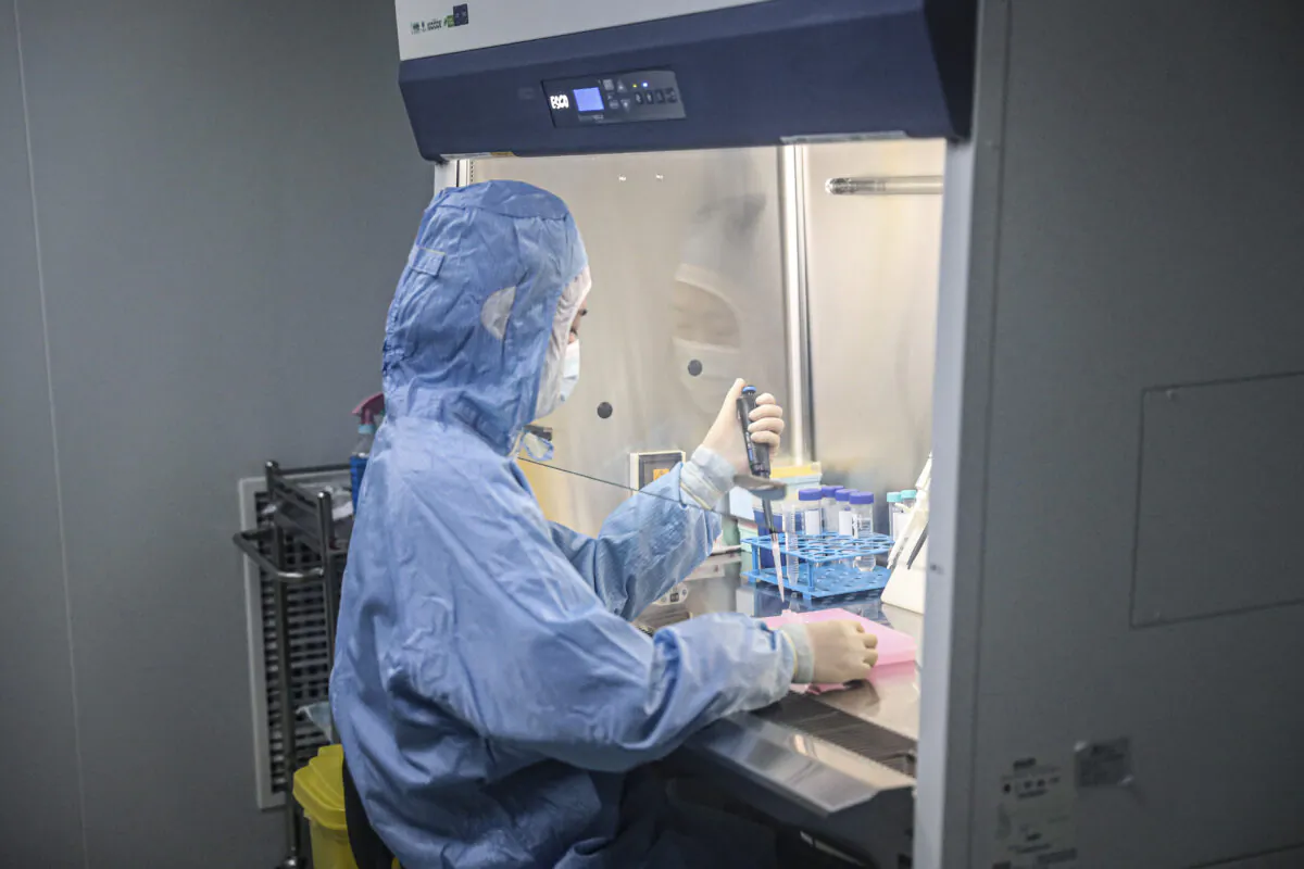 An employee works on Covid-19 coronavirus detection kits in a laboratory of the Chinese company Biotech & Biomedicine Group in Shenyang, China, on Dec. 14, 2020. (STR/AFP via Getty Images)