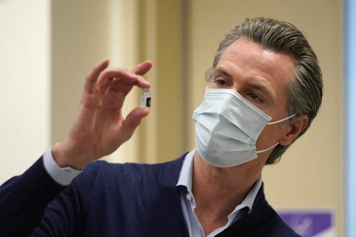 California Gov. Gavin Newsom holds up a vial of the new COVID-19 vaccine at Kaiser Permanente Los Angeles Medical Center in Los Angeles, Calif., on Dec. 14, 2020. (Jae C. Hong/Pool/Getty Images)