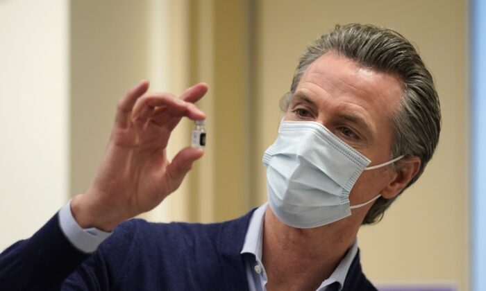 California Gov. Gavin Newsom holds up a vial of the new COVID-19 vaccine at Kaiser Permanente Los Angeles Medical Center in Los Angeles, Calif., on Dec. 14, 2020. (Jae C. Hong/Pool/Getty Images)