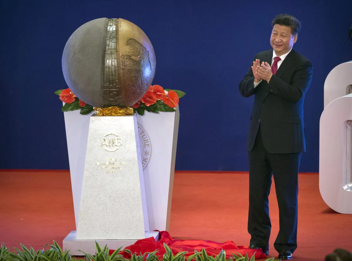 Chinese leader Xi Jinping applauds after unveiling a sculpture during the opening ceremony of the Asian Infrastructure Investment Bank in Beijing on Jan. 16, 2016. (AP Photo/Mark Schiefelbein, Pool)