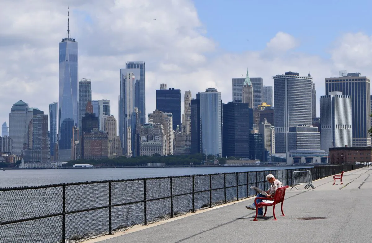 A man visits New York City's Governors Island, with the Manhattan skyline visible in the distance, on July 15, 2020. (Angela Weiss/AFP via Getty Images)