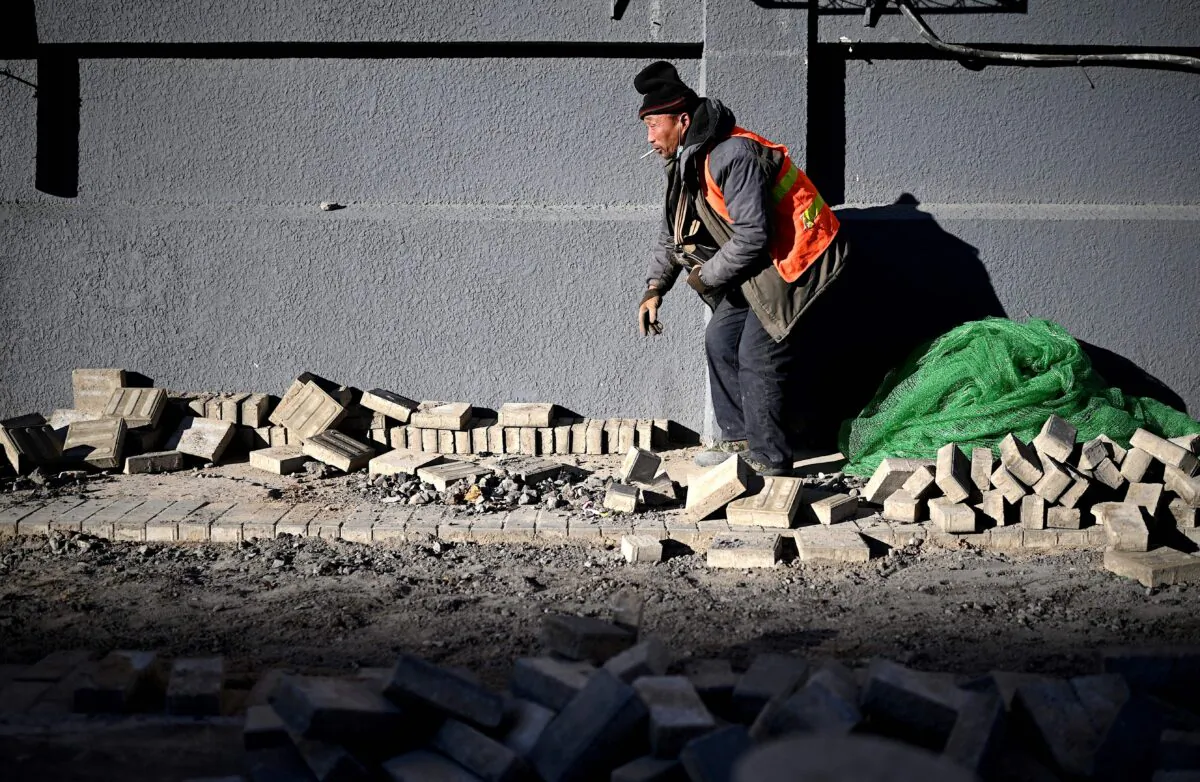 A worker lays bricks along a street in Beijing, China on Dec. 4, 2020. (NOEL CELIS/AFP via Getty Images)