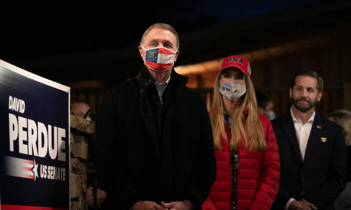 Sens. David Perdue (R-Ga.) (L) and Kelly Loeffler (R-Ga.) stand during a rally in Cumming, Ga., on Dec. 20, 2020. (Jessica McGowan/Getty Images)