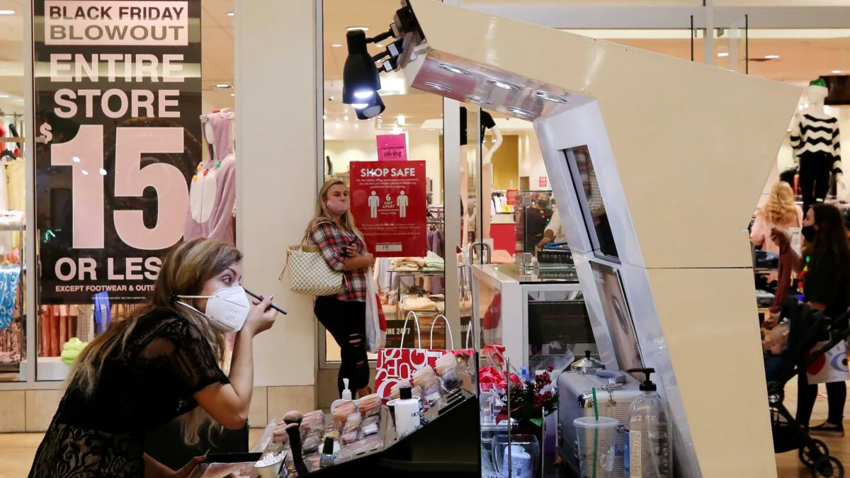 An employee wearing a protective mask applies makeup at Coastal Grand Mall on Black Friday, in Myrtle Beach, S.C., on Nov. 27, 2020. (Micah Green/Reuters)