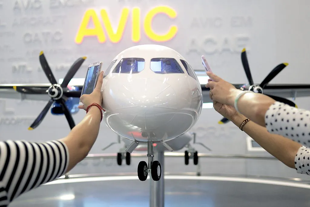 Visitors take photos of a MA700 plane model designed by Aviation Industry Corporation of China (AVIC) at the Beijing International Aviation Expo in Beijing on Sept. 17, 2015. (Wang Zhao/AFP via Getty Images)