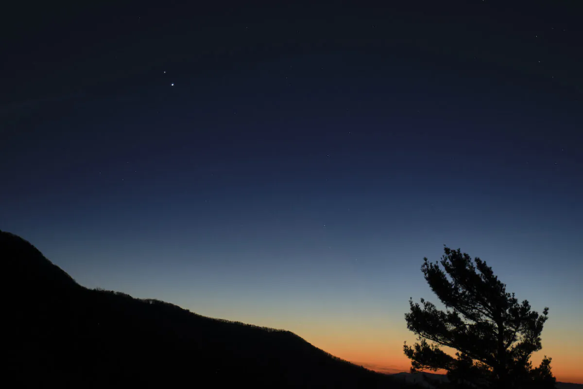 Saturn, top, and Jupiter, below, are seen after sunset from Shenandoah National Park, Sunday, Dec. 13, 2020, in Luray, Virginia. The two planets are drawing closer to each other in the sky as they head towards a “great conjunction” on December 21, where the two giant planets will appear a tenth of a degree apart. (NASA/Bill Ingalls)