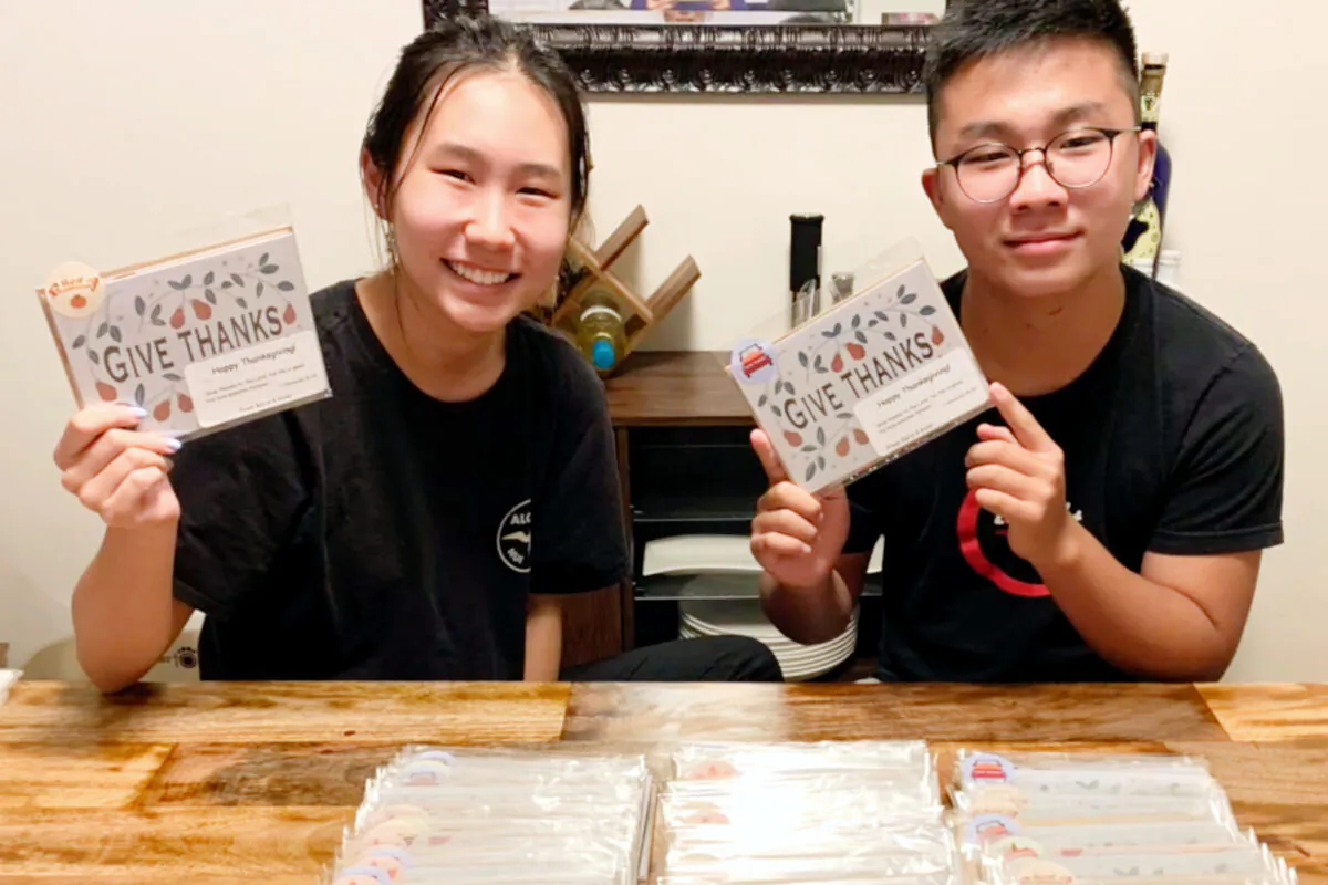 Siblings Karis and Kyler Choi hold up handcrafted Christmas cards for seniors. (Courtesy of Karis and Kyler Choi)