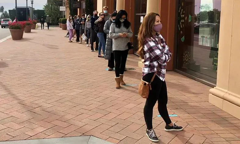 Shoppers wait in line outside the Fashion Island shopping center in Newport Beach, Calif., on Dec. 23, 2020. (Alex Murashko/The Epoch Times)