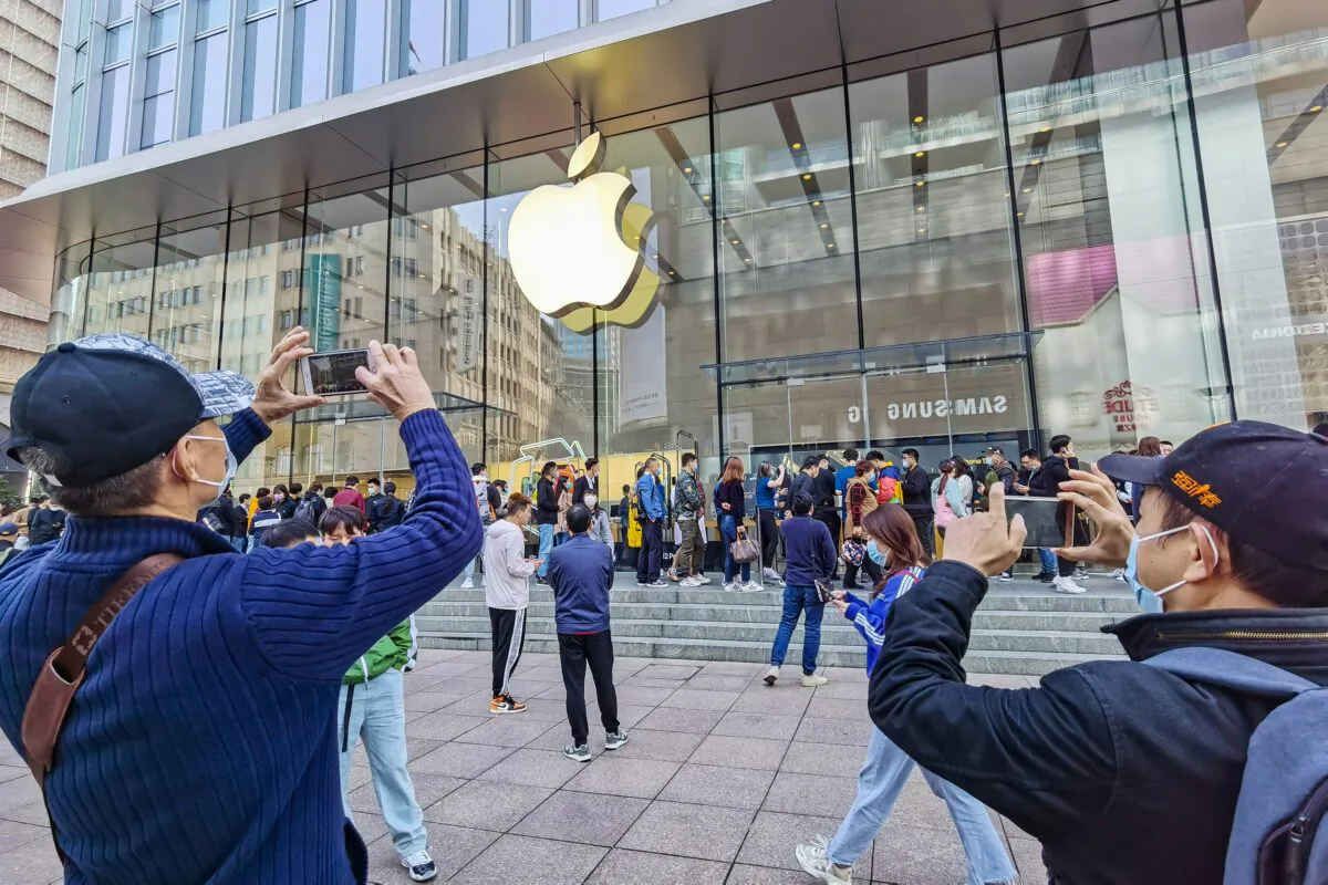 Customers queue to get their reserved iPhone 12 mobile phones at an Apple store in Shanghai, China on Oct. 23, 2020. (STR/AFP via Getty Images)