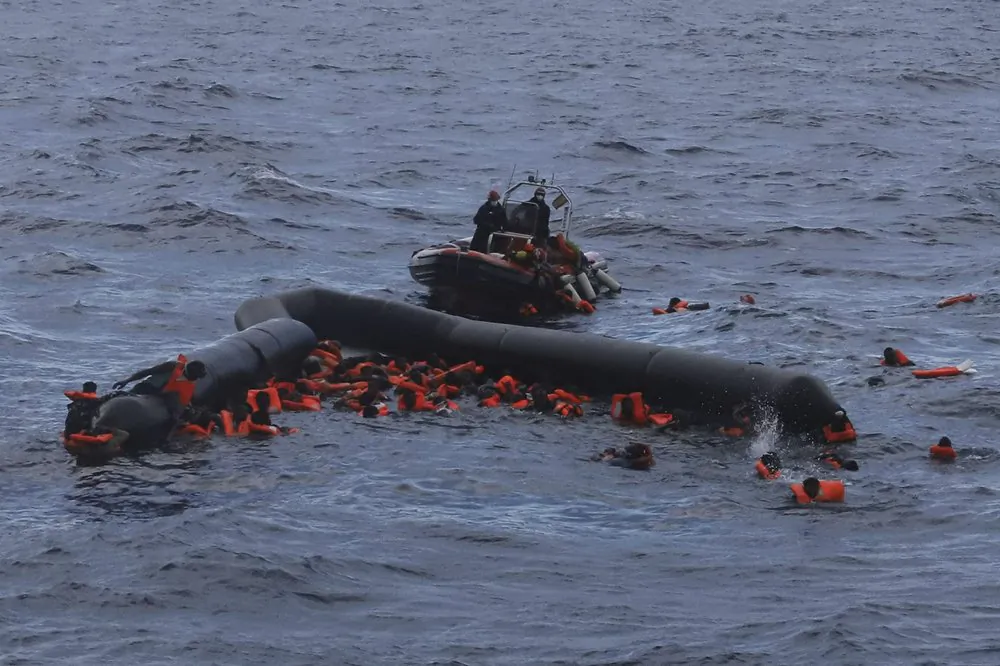 Refugees and migrants are rescued by members of the Spanish NGO Proactiva Open Arms, after leaving Libya trying to reach European soil aboard an overcrowded rubber boat in the Mediterranean sea. On Dec. 24, 2020. (AP Photo/file/Sergi Camara)