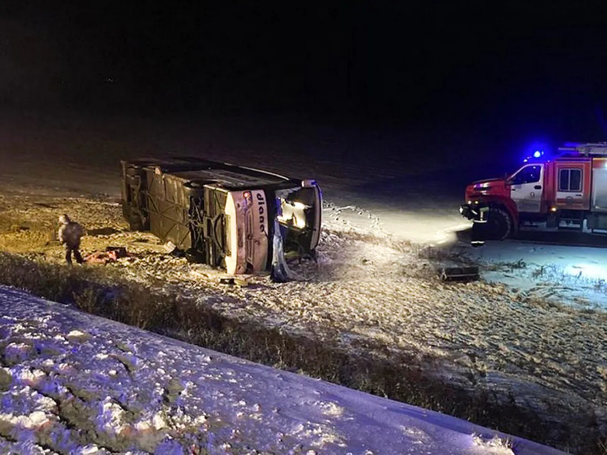This photo provided by the Government of Ryazan Region of Russia Press Office shows a bus which fell off a road near Vysokoye village, Russia, early Friday, Dec. 25, 2020.(Government of Ryazan Region of Russia Press Office via AP)