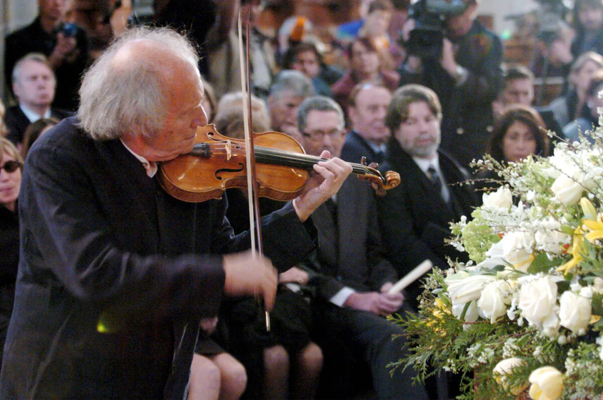 In this April 3 2004, Israeli violinist Ivry Gitlis, ambassador to the UNESCO, plays at the funeral ceremony of Oscar-winning British actor and play-writer, Sir Peter Ustinov, in the cathedral St. Pierre, in Geneva, Switzerland. (Martial Trezzini/Pool Photo via AP, File)