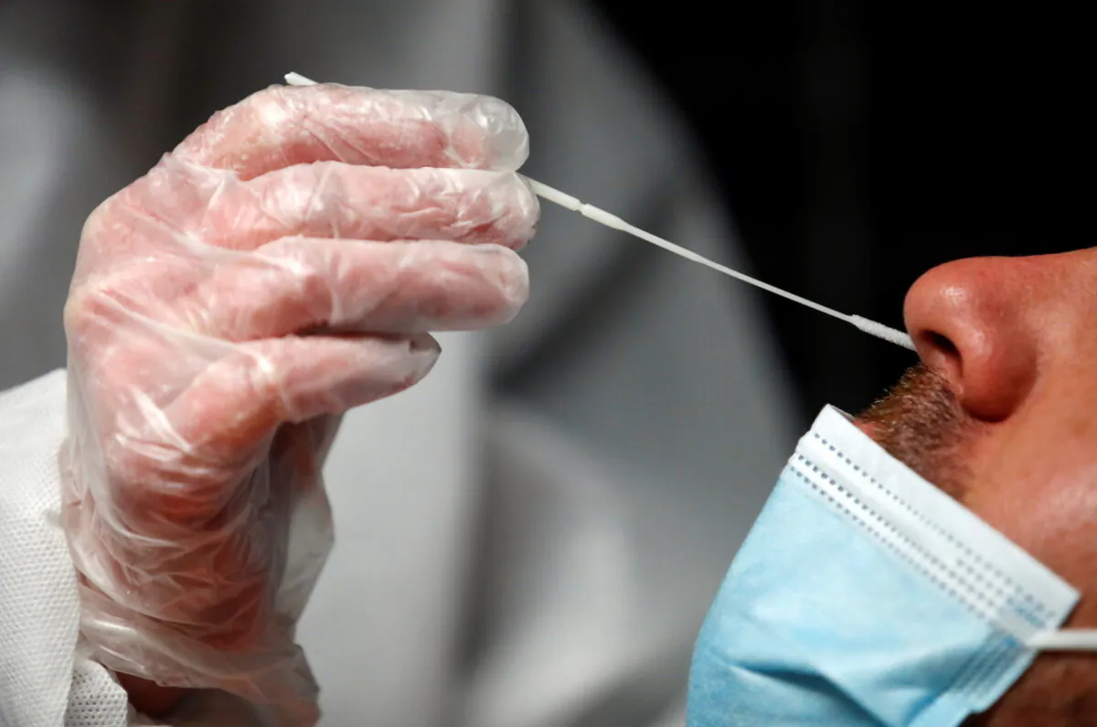 A medical worker administers a nasal swab to a patient at a COVID-19 testing centre in Le Bignon, France, on Dec.22, 2020. (Stephane Mahe/Reuters)