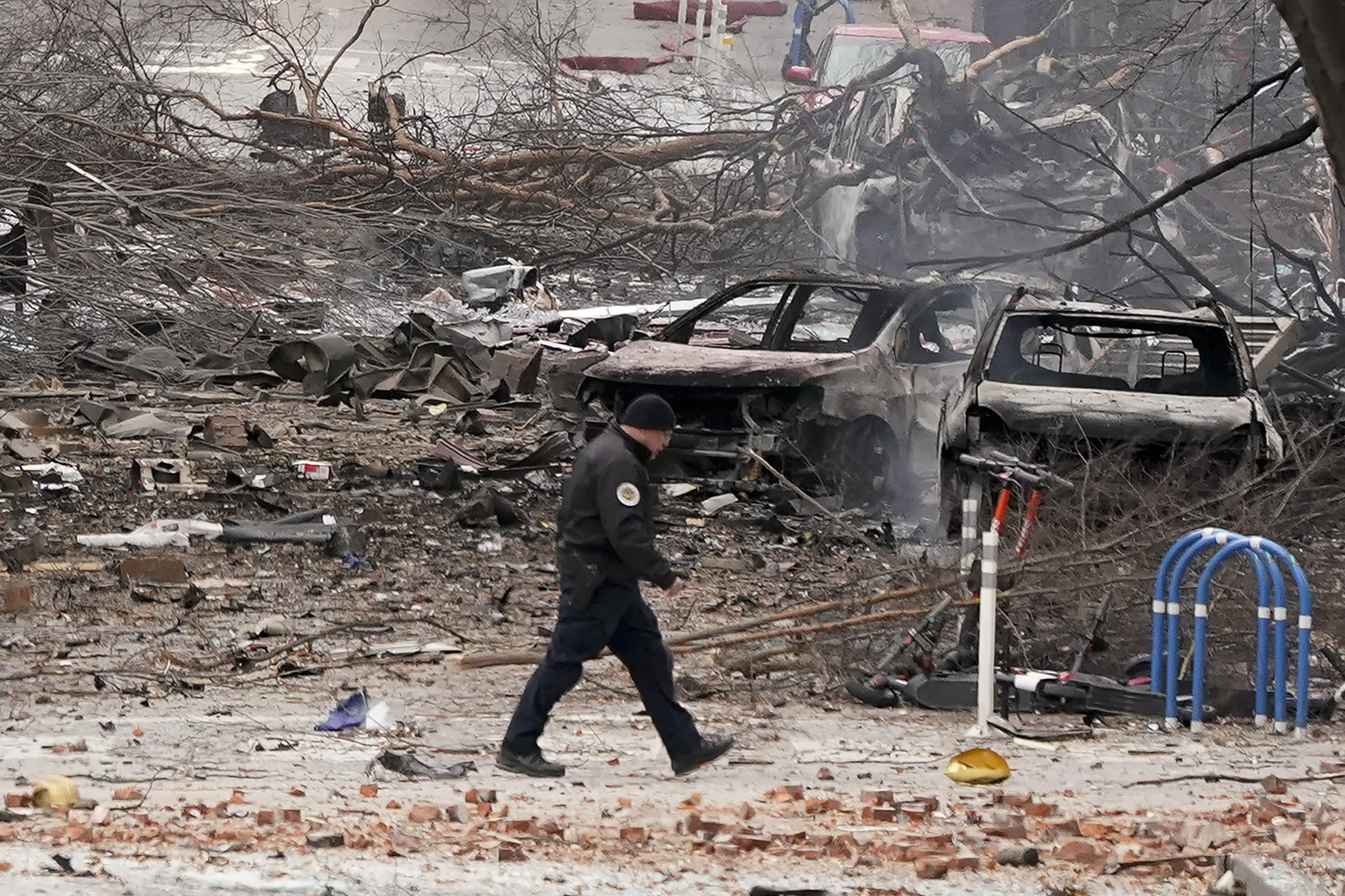 A law enforcement member walks past damage