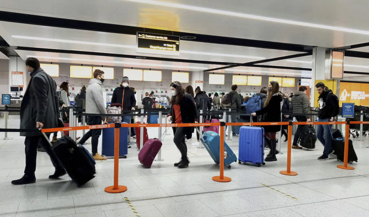 Passengers queue for check-in at Gatwick Airport in West Sussex, England, south of London, on Dec. 20, 2020. (Gareth Fuller/PA via AP)