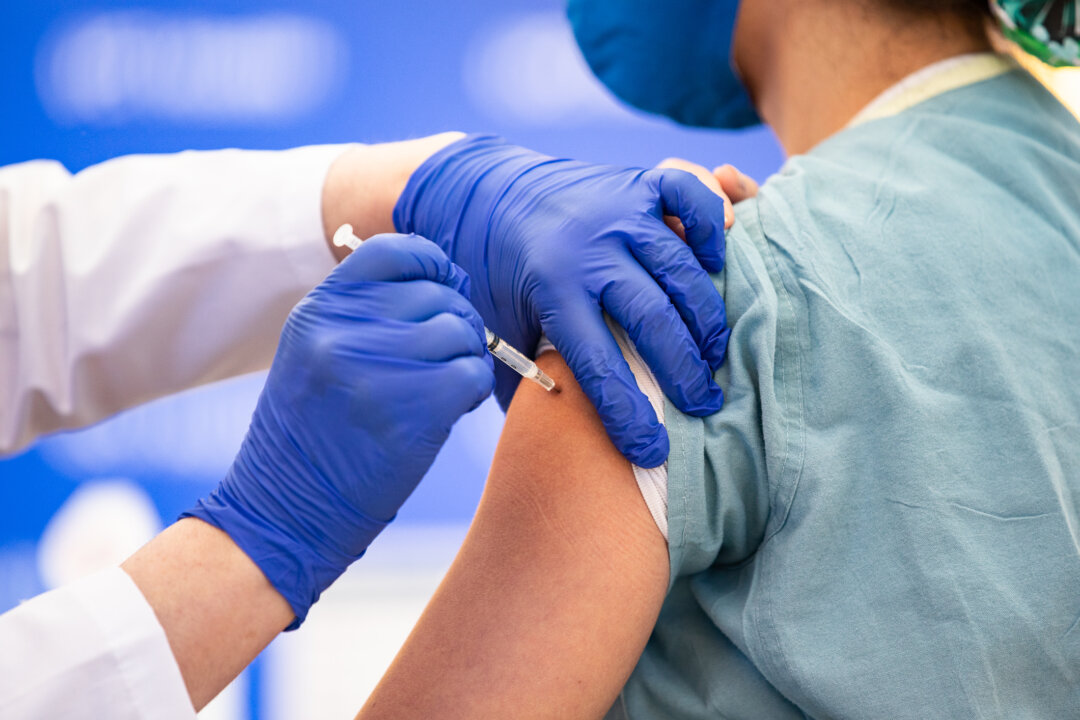 A nurse receives a COVID-19 vaccination at UCI Medical Center in Orange, Calif., on Dec. 16, 2020. (John Fredricks/The Epoch Times)