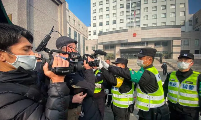 Police attempt to stop journalists from recording footage outside the Shanghai Pudong New District People's Court, where citizen journalist Zhang Zhan was sentenced, in Shanghai, China, on Dec. 28, 2020. (Leo Ramirez/AFP via Getty Images)