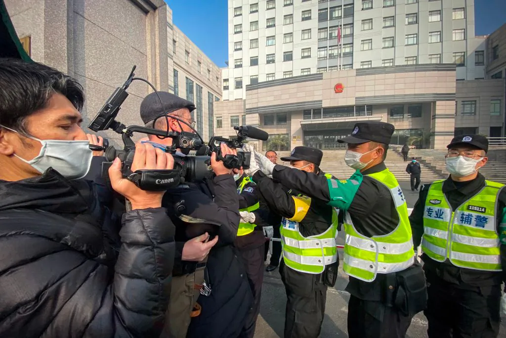 Police attempt to stop journalists from recording footage outside the Shanghai Pudong New District People's Court in Shanghai on Dec. 28, 2020. (Leo Ramirez/AFP via Getty Images)