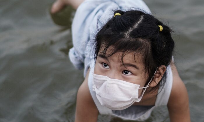 A girl plays in a flooded Jiangtan park in Wuhan, China on June 30, 2020. (Getty Images)