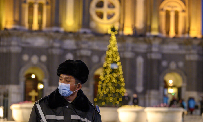 A security guard wearing a face mask stands guard at St. Joseph's Church during a mass on Christmas eve in Beijing on Dec. 24, 2020. (Noel Cells/AFP via Getty Images)