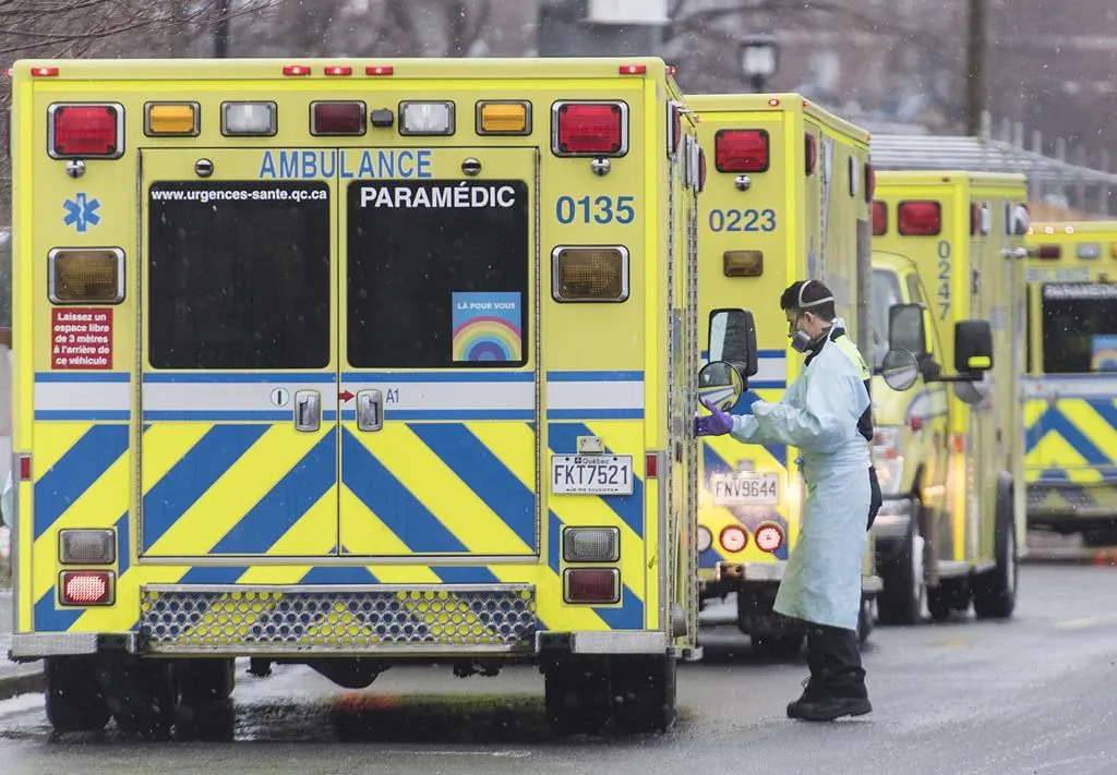 A paramedic stands next to an ambulance outside a hospital in Montreal on Dec. 28, 2020. (The Canadian Press/Graham Hughes)