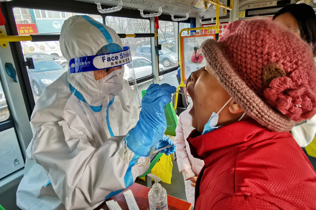 A health worker takes a swab from a resident to test for the COVID-19 in Dalian, China on Dec. 23, 2020. (STR/AFP via Getty Images)