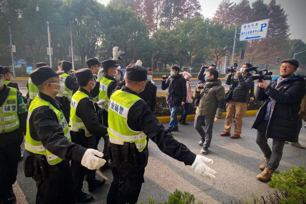 Police attempt to stop journalists from recording footage outside the Pudong New District People's Court in Shanghai, on Dec 28, 2020. (Leo Ramirez/AFP via Getty Images)