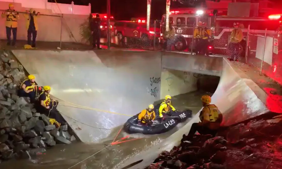 Members of the Orange County Fire Authority prepare to rescue two adults trapped in flowing water beneath an overpass in Santa Ana, Calif., on Dec. 28, 2020. (Screenshot/Twitter/Orange County Fire Authority)