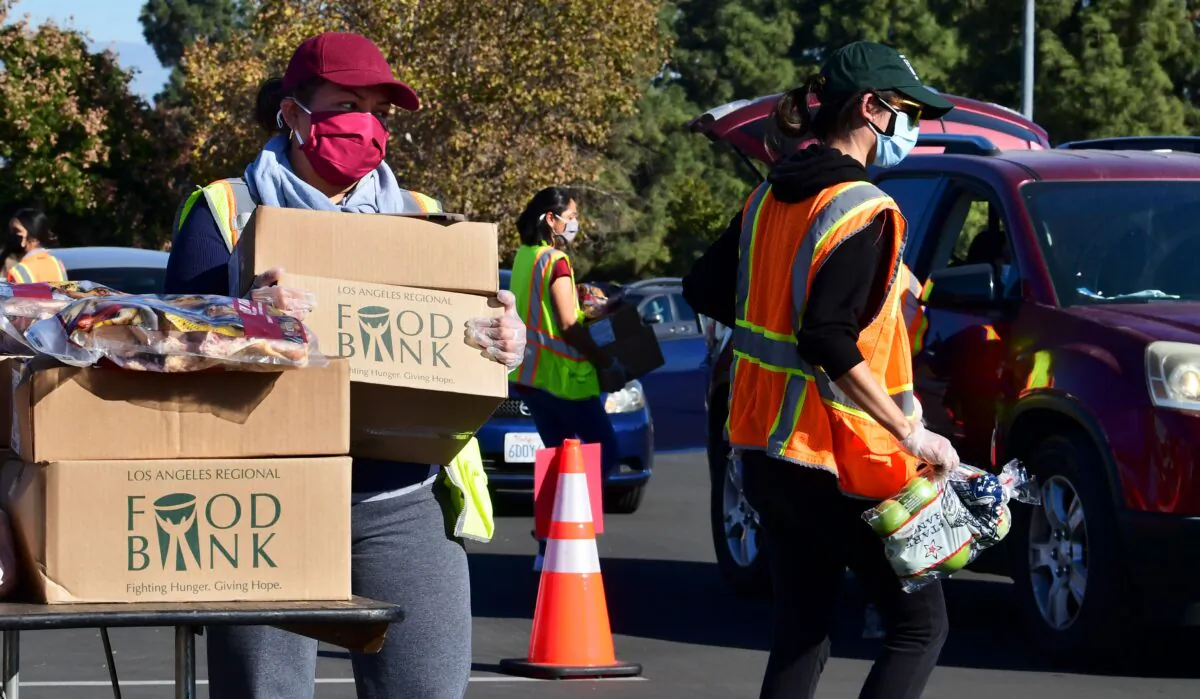 Food is loaded as drivers in their vehicles wait in line on arrival at a food distribution hosted by the Los Angeles Food Bank in Hacienda Heights, Calif., on Dec. 4, 2020. (Frederic J. Brown/AFP via Getty Images)