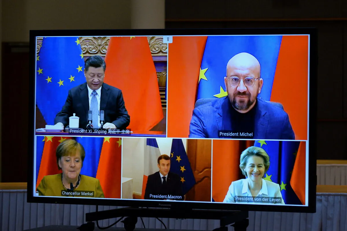 European Commission President Ursula von der Leyen, European Council President Charles Michel, German Chancellor Angela Merkel, French President Emmanuel Macron, and Chinese President Xi Jinping are seen on a screen during a video conference, in Brussels, on Dec. 30, 2020. (Johanna Geron/Pool/Reuters)