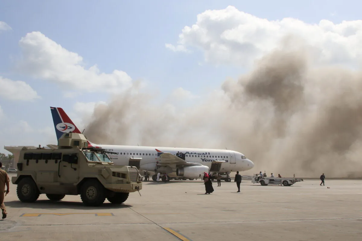 A military vehicle is seen on the tarmac as dust rises after explosions hit Aden airport, in Aden, Yemen, on Dec. 30, 2020. (Fawaz Salman/Reuters)