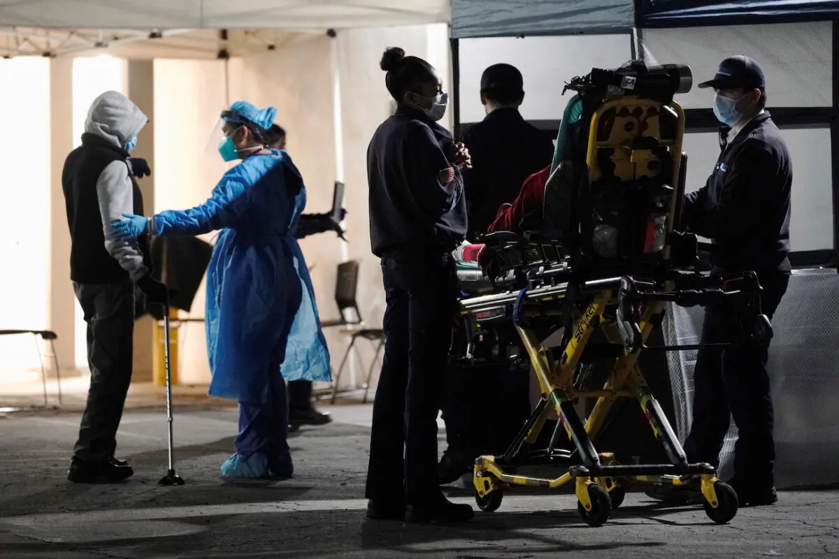 Health care workers treat patients outside the emergency room at the Community Hospital of Huntington Park in Huntington Park, Calif., on Dec. 29, 2020. (Bing Guan/Reuters)