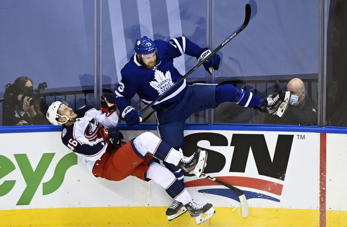 Hockey action between Toronto Maple Leafs left-winger Kyle Clifford and Columbus Blue Jackets defenceman Dean Kukan during the first period NHL Eastern Conference Stanley Cup playoffs in Toronto on Aug. 4, 2020. (The Canadian Press/Nathan Denette)