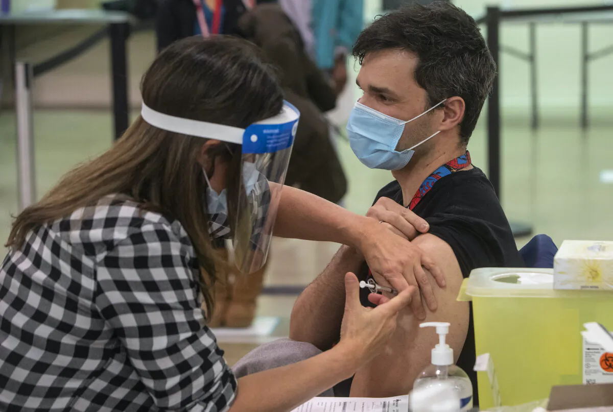 A nurse injects a man with a COVID-19 vaccine in Edmonton on Dec. 15, 2020. (The Canadian Press/Jason Franson)