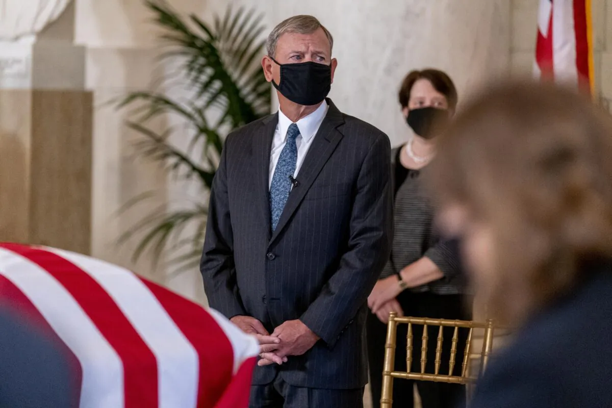 Supreme Court Chief Justice John Roberts watches as the flag-draped casket of Associate Justice Ruth Bader Ginsburg is carried in the Great Hall at the Supreme Court in Washington on Sept. 23, 2020. (Andrew Harnik/Pool/Getty Images)