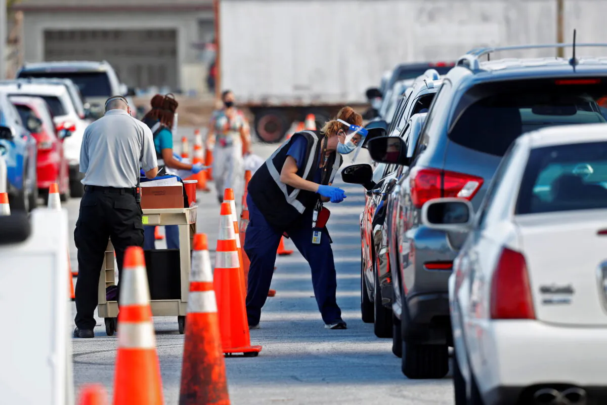 Florida Department of Health medical workers prepare to administer a COVID-19 vaccine to seniors in the parking lot of the Gulf View Square Mall in New Port Richey near Tampa, Fla., on Dec. 31, 2020. (Octavio Jones/Reuters)
