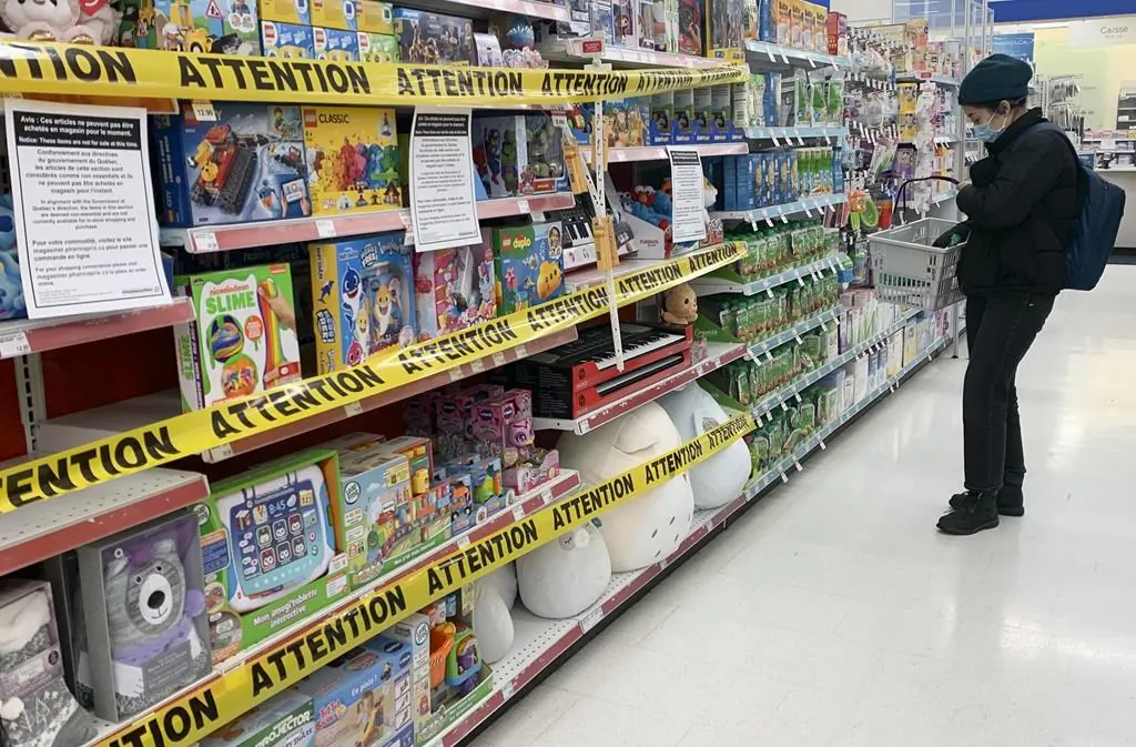 Tape is shown on shelves preventing the sale of non-essential products at a pharmacy in Montreal on Jan. 3, 2021. (The Canadian Press/Graham Hughes)