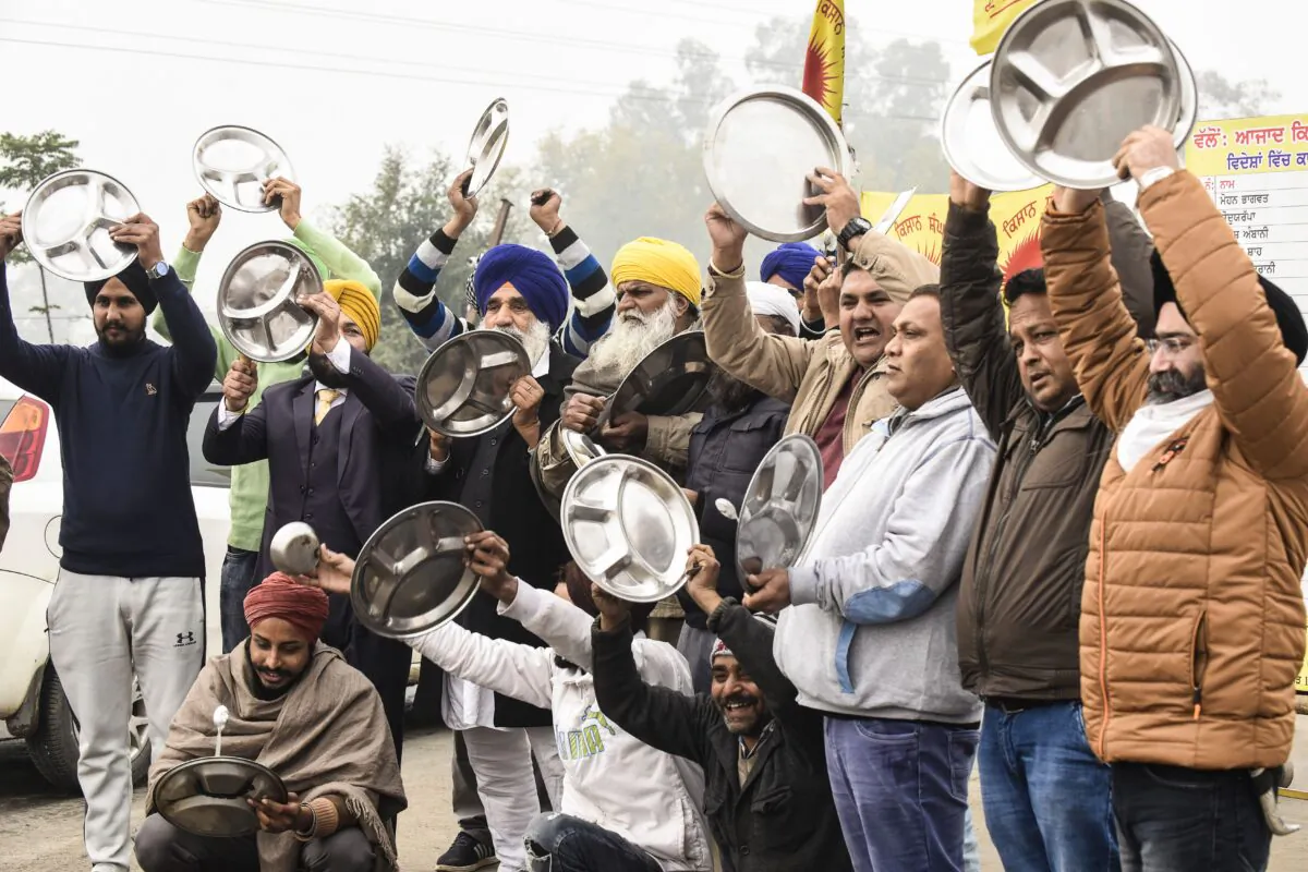Farmers beat utensils during a protest against the central government's recent agricultural reforms as India's Prime Minister Narendra Modi addressed the nation on the monthly radio programme 'Mann Ki Baat', at the Toll Plaza, on the outskirts of Amritsar on Dec. 27, 2020. (Narinder Nanu/AFP via Getty Images)
