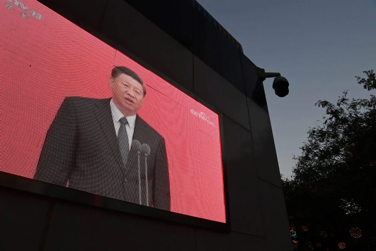 A video clip of Chinese Leader Xi Jinping is seen on the outside of a police patrol station in Beijing on Nov. 2, 2020. (Photo by GREG BAKER / AFP via Getty Images)