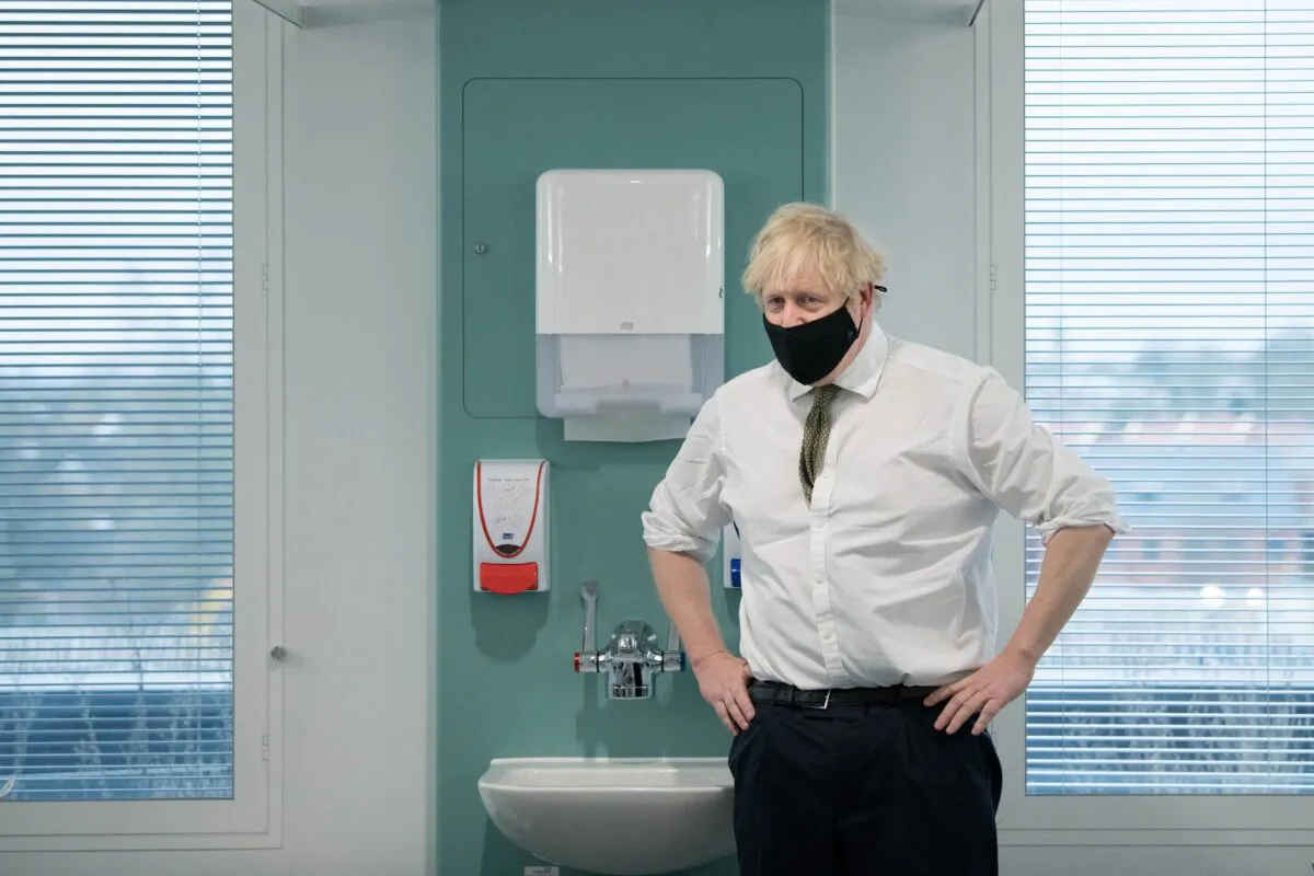 Britain's Prime Minister Boris Johnson speaks to NHS staff (unseen) waiting to receive a dose of the AstraZeneca/Oxford COVID-19 vaccine during a visit to Chase Farm Hospital in north London on Jan. 4, 2021. (Stefan Rousseau/Pool/AFP via Getty Images)