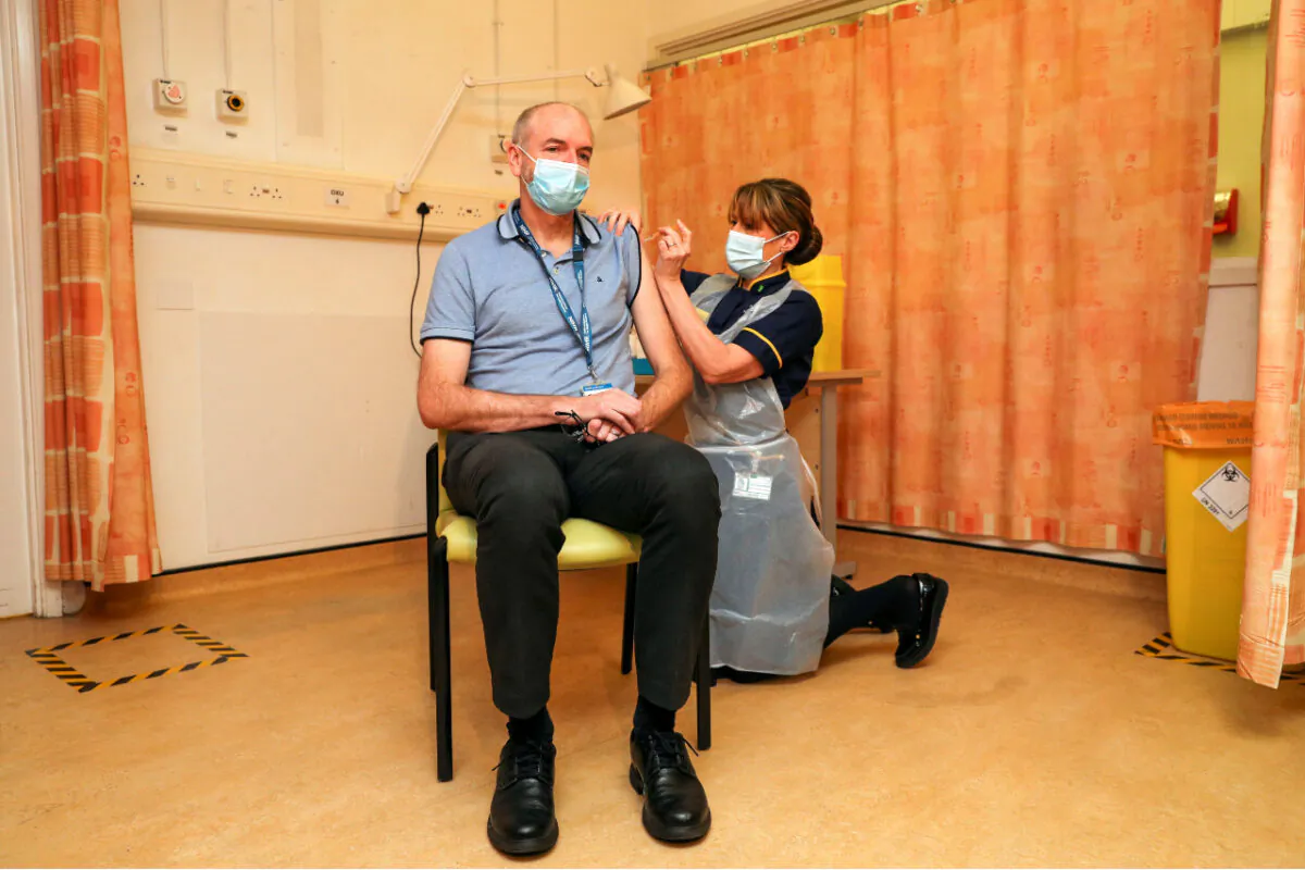 Professor Andrew Pollard, Director of the Oxford Vaccine Group (OVG), and a professor of Paediatric Infection and Immunity receives the Oxford University/AstraZeneca CCP virus vaccine from nurse Sam Foster at the Churchill Hospital in Oxford, England on Jan. 4, 2021. (Steve Parsons/Pool Photo/AP)
