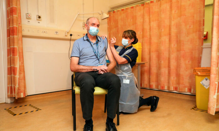 Professor Andrew Pollard, Director of the Oxford Vaccine Group (OVG), and a professor of Paediatric Infection and Immunity receives the Oxford University/AstraZeneca CCP virus vaccine from nurse Sam Foster at the Churchill Hospital in Oxford, England on Jan. 4, 2021. (Steve Parsons/Pool Photo/AP)