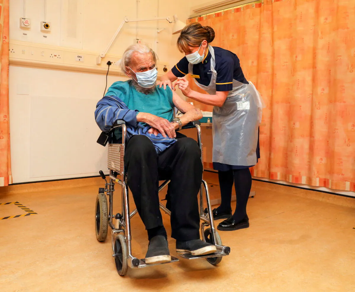 Trevor Cowlett, 88, receives the Oxford University/AstraZeneca COVID-19 vaccine from nurse Sam Foster at the Churchill Hospital in Oxford, England on Jan. 4, 2021. (Steve Parsons/Pool via Reuters)