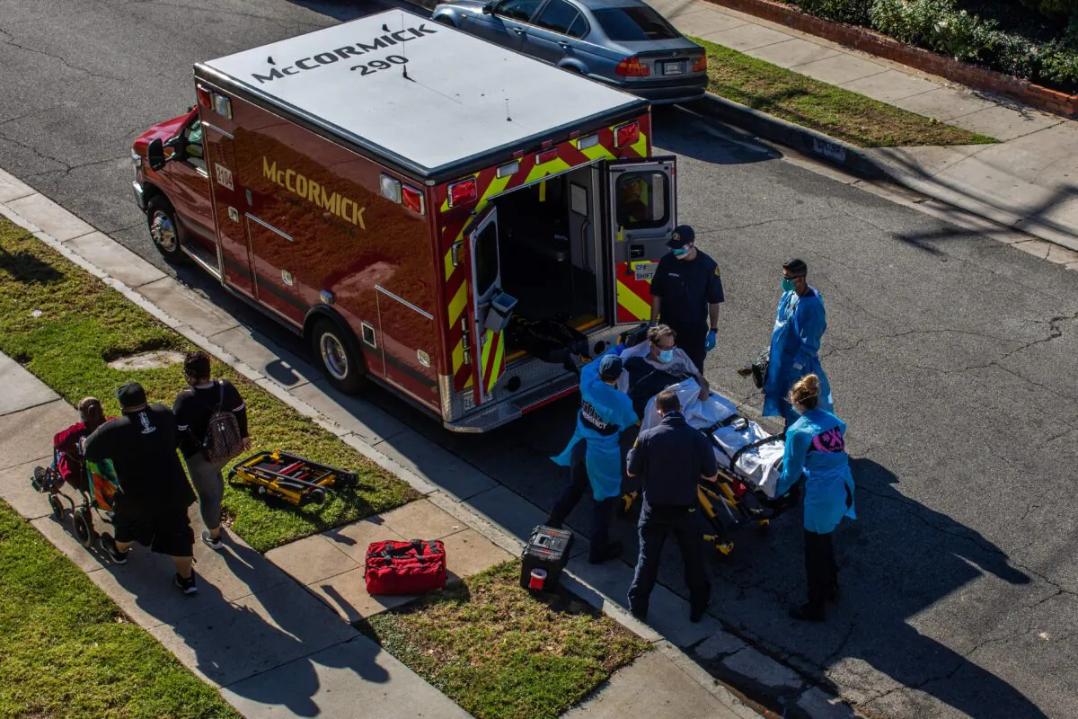 After administering oxygen, County of Los Angeles paramedics load a patient in the ambulance before transporting him to a hospital in Hawthorne, Calif., on Dec. 29, 2020. (Apu Gomes/AFP via Getty Images)