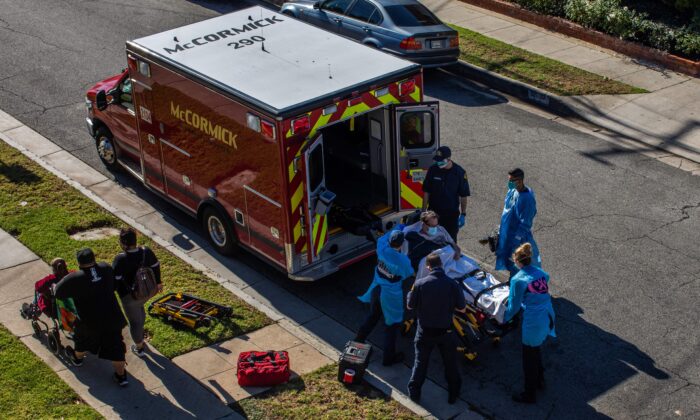 After administering him with oxygen, Los Angeles paramedics load a potential COVID-19 patient in the ambulance before transporting him to a hospital in Hawthorne, California, on Dec. 29, 2020. (Apu Gomes/AFP via Getty Images)
